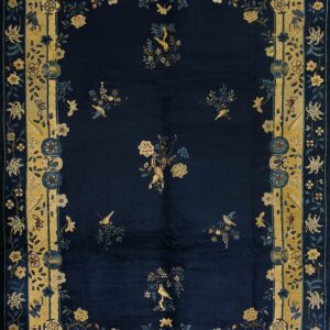 Dark blue rug featuring scattered floral sprigs and birds, framed by a broad gold and light blue ornamental border.
