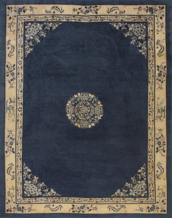Navy blue rug featuring a central floral medallion and detailed light tan borders with blue designs.