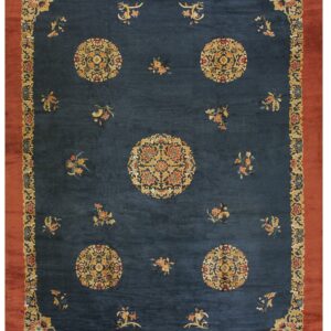 Ornate indigo rug featuring gold floral medallions and a broad solid rust red outer border.