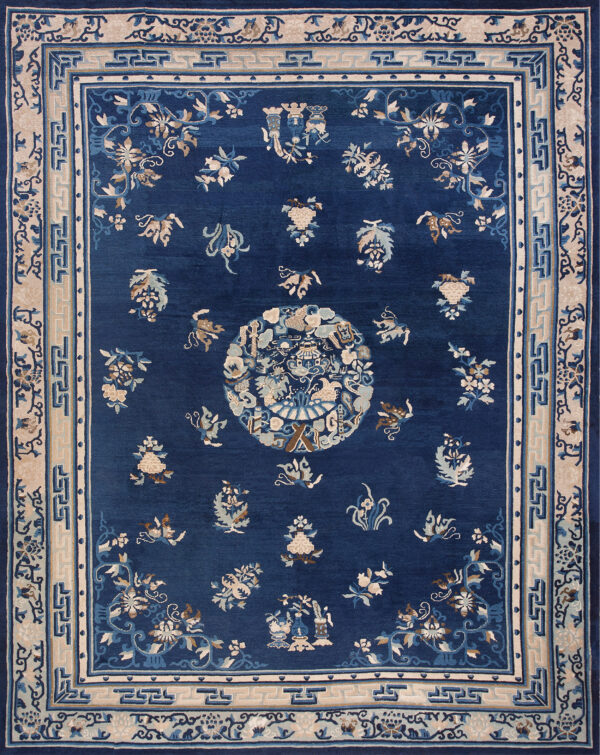 Dark blue rug featuring a central medallion and scattered floral motifs in cream, tan, and light blue.