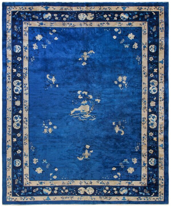 Deep royal blue rug featuring scattered tan and light blue traditional pictorial motifs and elaborate floral borders.
