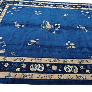 High-pile royal blue rug with scattered beige floral motifs and a complex multi-banded border.