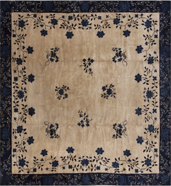 Light beige rug featuring deep blue floral motifs, vines, and a wide decorative navy blue border.