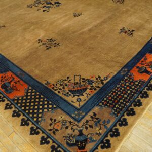 Camel rug corner showing scattered florals and complex navy and terracotta borders on light wood plank flooring.