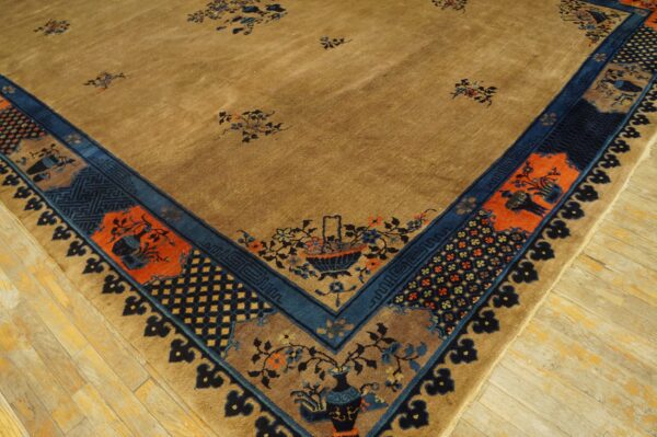 Camel rug corner showing scattered florals and complex navy and terracotta borders on light wood plank flooring.