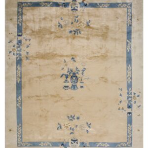 High-sheen beige rug featuring blue floral and vase designs within a thick blue rectilinear border.
