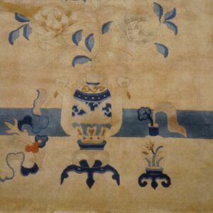 Detail of a plush beige rug showing stylized blue and cream floral arrangements in decorative vases.