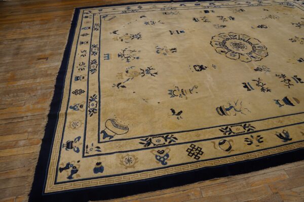 Tan low-pile rug with blue scattered symbols and a medallion on rustic wood plank flooring.