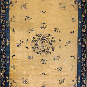 Pale yellow area rug with navy blue floral borders and scattered blue motifs across the field.