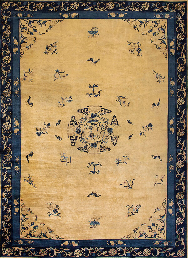 Pale yellow area rug with navy blue floral borders and scattered blue motifs across the field.