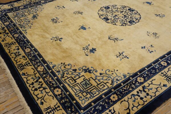 Pale yellow rug with dark and light blue motifs, a large circular medallion, and a wide geometric border.