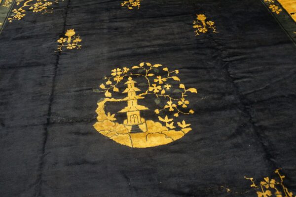 Plush dark blue rug features a detailed golden yellow pagoda and scattered floral motifs.