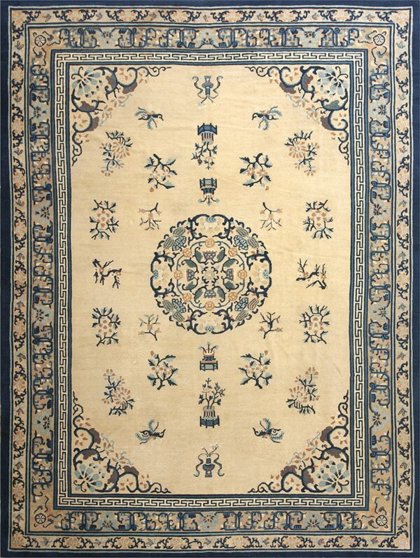 Beige rug with navy blue and teal floral sprays, a central medallion, and multiple detailed borders.