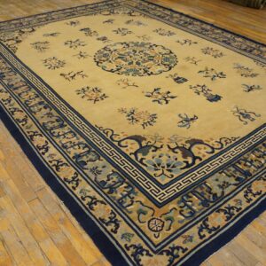 Traditional yellow rug featuring blue and tan borders, placed over light colored hardwood flooring.