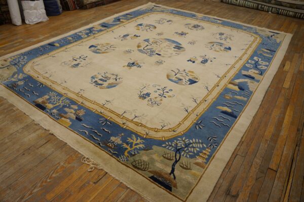 Cream and blue scenic pattern rug with a bamboo border rests on distressed wood flooring.