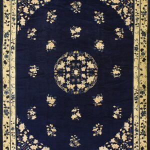 Navy rug featuring a cream floral medallion, scattered bouquets, and a wide pale yellow border.