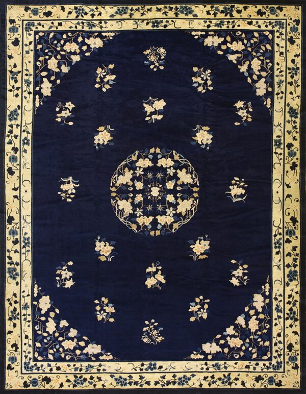 Navy rug featuring a cream floral medallion, scattered bouquets, and a wide pale yellow border.