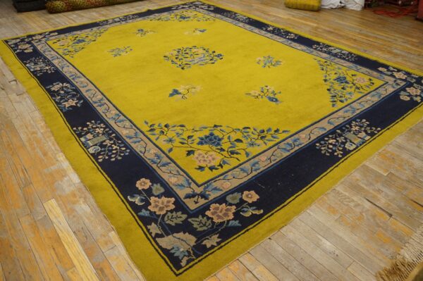 Bright chartreuse rug with a navy blue and floral patterned border displayed on distressed wood floors.