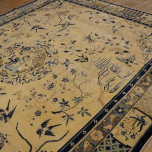 Beige rug featuring a detailed pattern of blue birds and branches, surrounded by a navy geometric border.