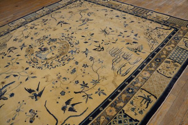 Beige rug featuring a detailed pattern of blue birds and branches, surrounded by a navy geometric border.