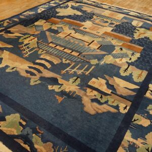 Deep indigo scenic rug with tan, green, and brown architectural and landscape elements on wood plank flooring.