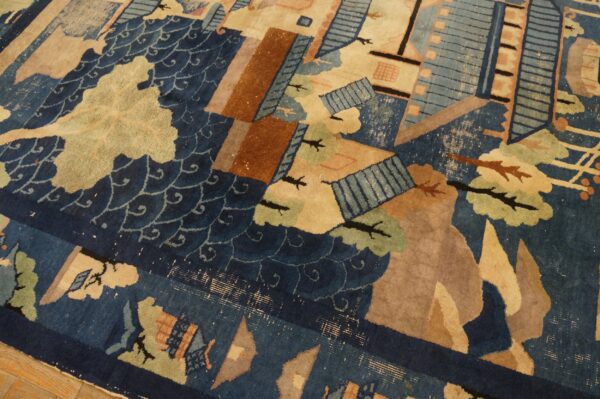 Blue and beige rug displaying a stylized landscape pattern with brown geometric shapes over hardwood.