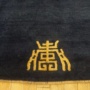 Dark blue high-pile rug featuring a prominent golden patterned symbol on light wooden floors.