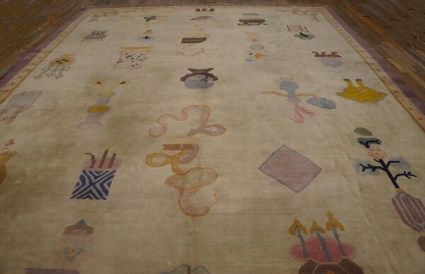 Large pale rug with a whimsical, scattered pattern in pastel colors on dark wood flooring.