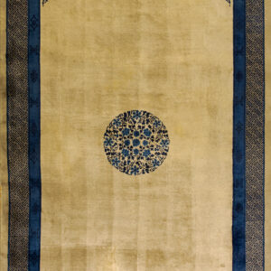Gold rug featuring a center blue floral medallion, corner floral sprays, and complex geometric borders.