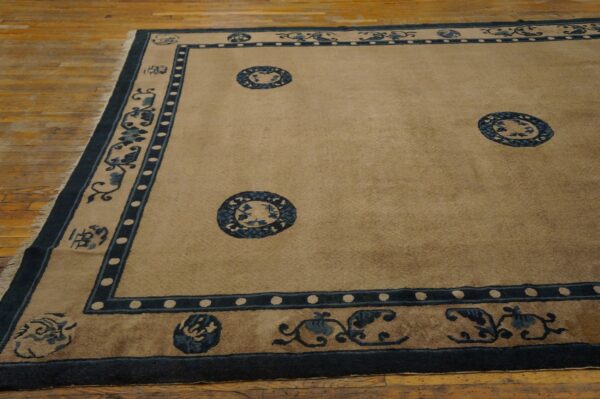 Beige low pile rug with dark blue floral borders and medallions displayed on light wooden flooring.