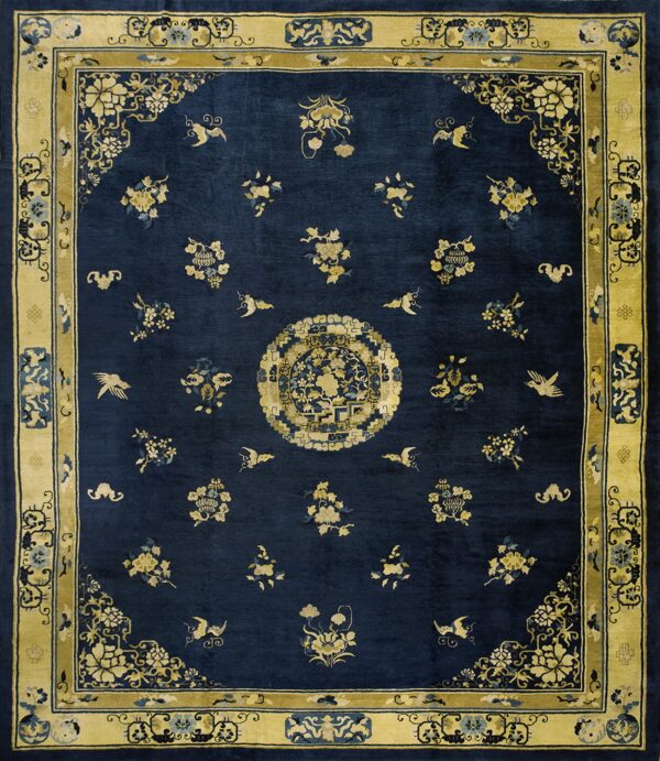 Navy blue rug with a gold border and central medallion, featuring scattered floral and bird patterns.