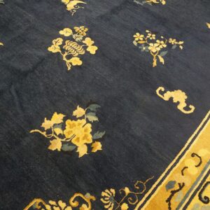 Navy field rug with scattered yellow botanical and bird motifs bordering a golden yellow band.