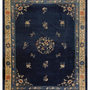 Dark blue rug featuring a light beige floral border and scattered coordinating motifs in the central field.