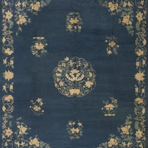 Deep blue rug featuring a central medallion and scattered tan and green floral sprays and a complex border.