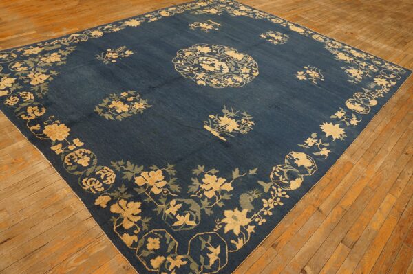 Navy area rug featuring high-contrast gold and sage floral patterns on rustic wood flooring.