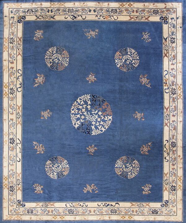 Blue rug with a wide cream and tan border, featuring five large circular floral medallions.