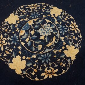 Navy rug detail showing a dense circular floral medallion pattern in cream and various blues.