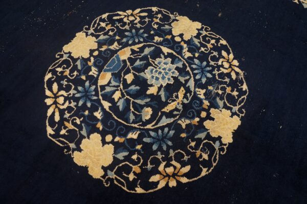 Navy rug detail showing a dense circular floral medallion pattern in cream and various blues.