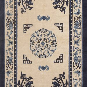 Beige and navy blue rug featuring a central medallion and complex borders with floral and butterfly patterns.