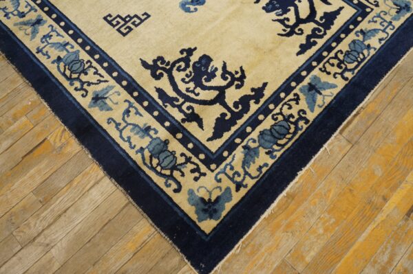 Cream rug with detailed navy and dusty blue floral and butterfly borders on distressed wood planks.