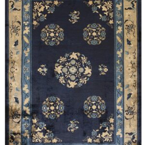 A plush navy rug featuring tan and light blue stylized floral medallions and wide decorative borders.