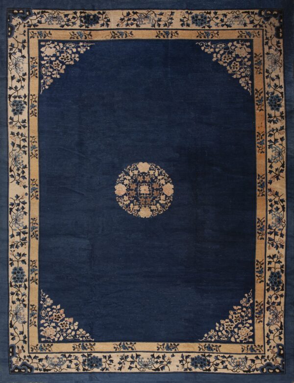 Navy blue rug with a small central medallion and wide beige border detailed with floral motifs.