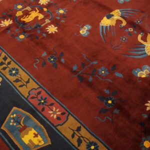 Deep red rug with gold and blue animal and floral patterns, featuring a contrasting dark navy and brown border.