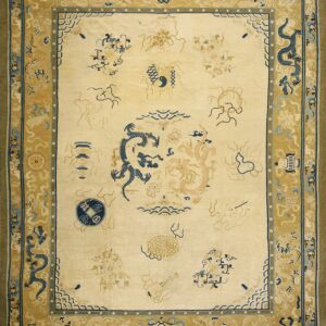 An ivory rug displays dark blue and tan dragon designs surrounded by a detailed gold border.