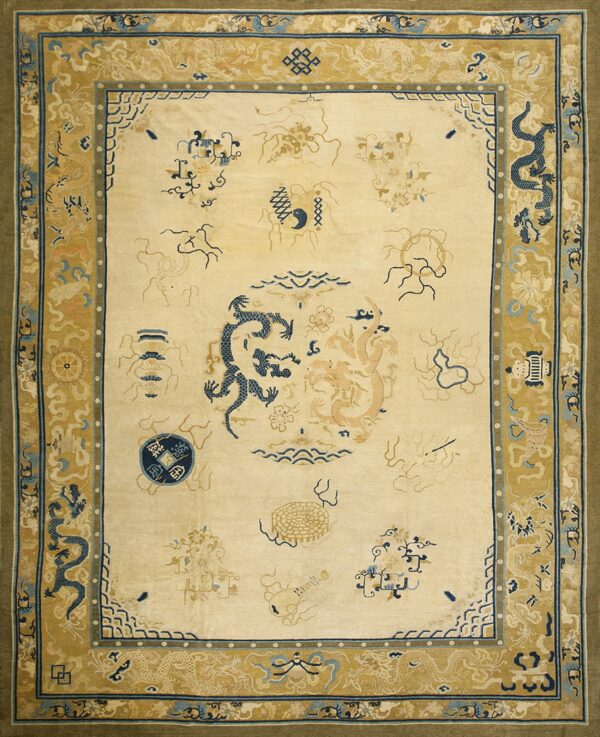 An ivory rug displays dark blue and tan dragon designs surrounded by a detailed gold border.