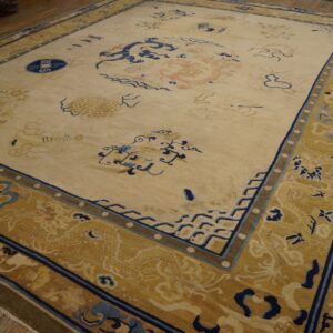 Large cream rug with intricate blue and pink dragon patterns, featuring a wide gold border.