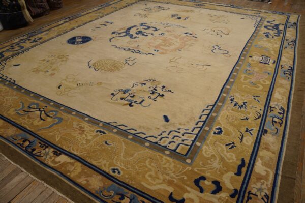 Large cream rug with intricate blue and pink dragon patterns, featuring a wide gold border.