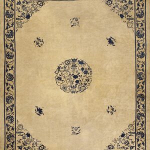 Light tan rug with navy blue designs, including a detailed central medallion and repeating floral border.
