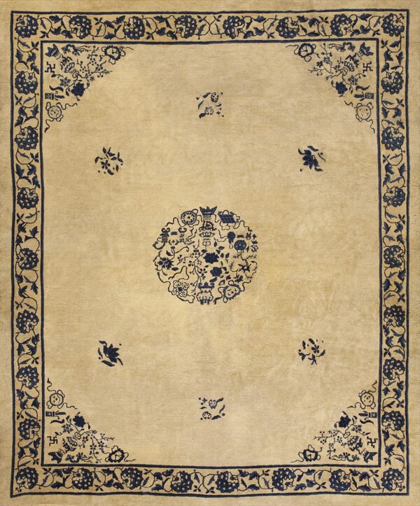 Light tan rug with navy blue designs, including a detailed central medallion and repeating floral border.