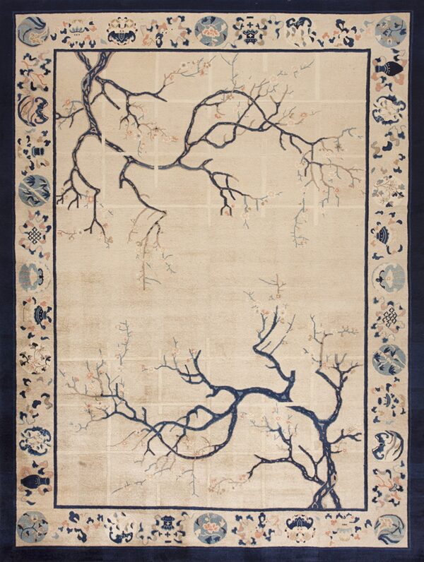 A beige rug with a navy blue border features a blossoming tree branch pattern in the center.